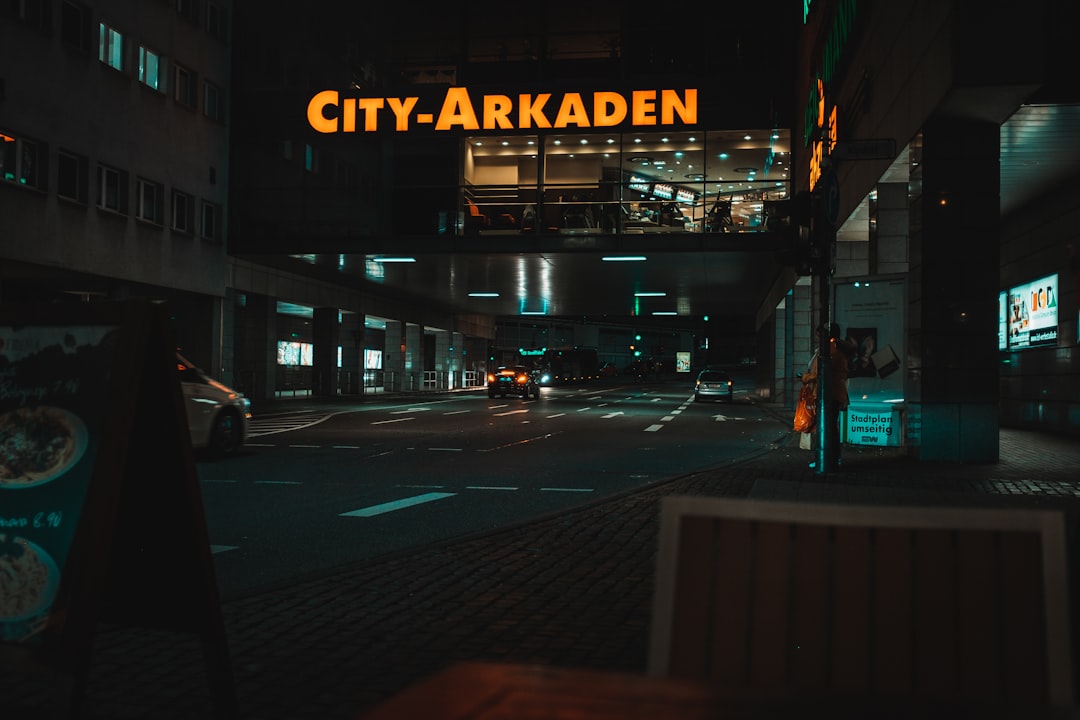 a city - arkaden sign is lit up at night